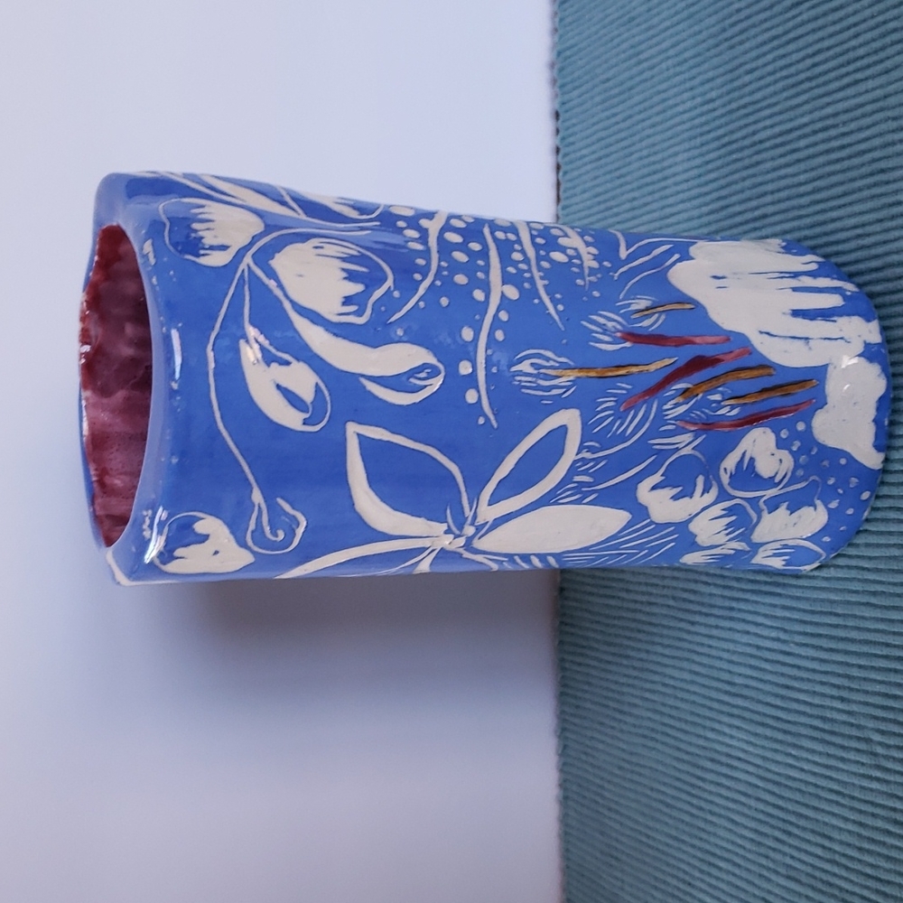 Signed pottery vase. Blue with white flowers, mauve and gold accents. Signed